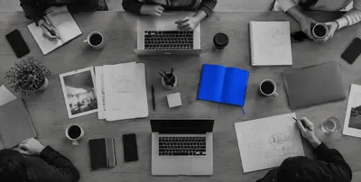 Team working at a table from above, blue notebook